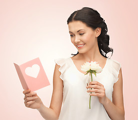 Image showing young woman holding flower and postcard