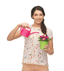 Image showing housewife with flower in pot and watering can