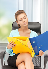 Image showing young businesswoman with folders sitting in chair