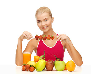 Image showing woman with organic food eating strawberry