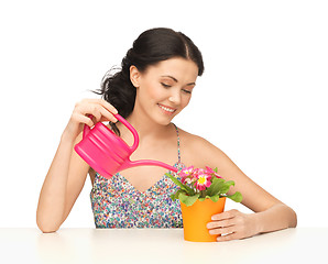 Image showing housewife with flower in pot and watering can