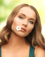 Image showing woman with camomile in mouth