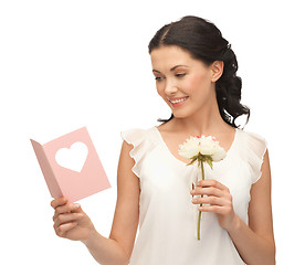 Image showing young woman holding flower and postcard