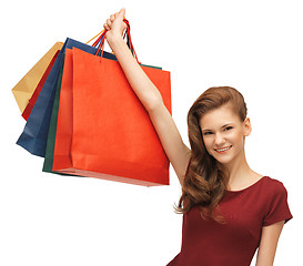 Image showing teenage girl in red dress with shopping bags