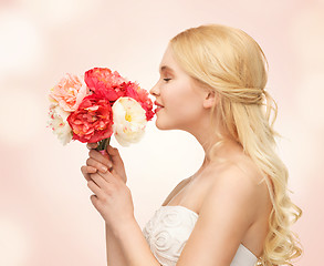 Image showing woman smelling bouquet of flowers