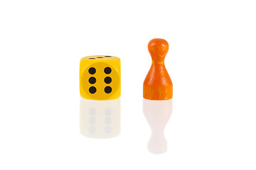 Image showing One orange pawn and a yellow dice 