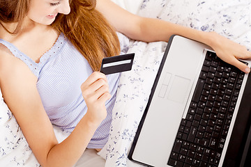 Image showing girl sitting in bed and shopping online with credit card