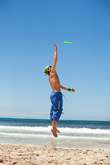 Image showing attractive man playing frisby on beach in summer