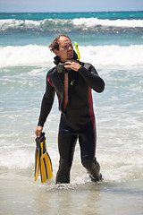 Image showing male diver with diving suit snorkel mask fins on the beach