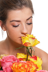 Image showing attractive young smiling woman with flowers roses isolated