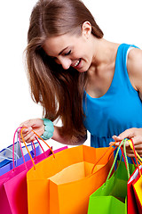 Image showing attractive young woman with colorful shopping bags isolated