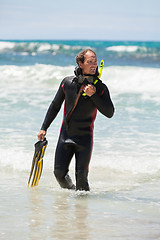 Image showing male diver with diving suit snorkel mask fins on the beach