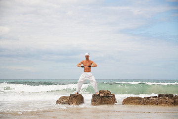 Image showing healthy man doing pilates yoga meditation on beach summer