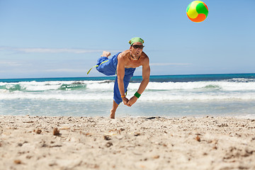 Image showing attractive young man playing volleyball on the beach