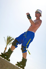 Image showing young man with inline skates in summer outdoor 