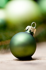 Image showing shiny green christmas baubles closeup macro and tree 