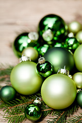 Image showing shiny green christmas baubles closeup macro and tree 