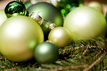 Image showing shiny green christmas baubles closeup macro and tree 