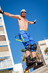 Image showing young man with inline skates in summer outdoor 