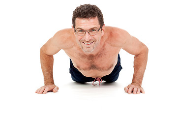 Image showing adult smiling man doing workout pushups isolated