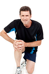 Image showing adult attractive man in sportswear knee pain injury ache isolated