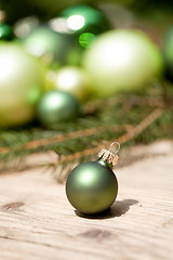 Image showing shiny green christmas baubles closeup macro and tree 