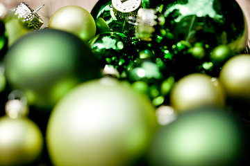 Image showing shiny green christmas baubles closeup macro and tree 