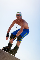 Image showing young man with inline skates in summer outdoor 