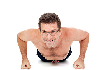 Image showing adult smiling man doing workout pushups isolated