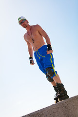 Image showing young man with inline skates in summer outdoor 