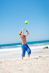 Image showing attractive young man playing volleyball on the beach