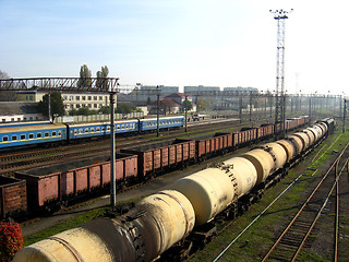 Image showing The cars of a freight train and tank trucks