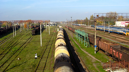 Image showing The cars of a freight train and tank trucks