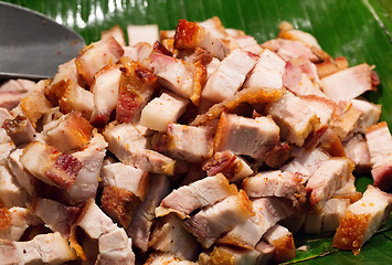 Image showing Roast pork cut into pieces on palm leaf
