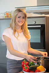 Image showing Pretty blond woman preparing a meal