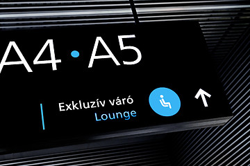 Image showing Black airport terminal sign with blue symbols