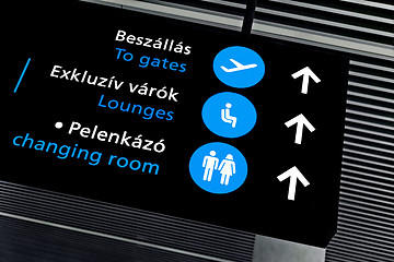 Image showing Black airport terminal sign with blue symbols