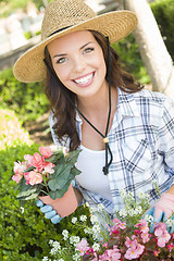 Image showing Young Adult Woman Wearing Hat Gardening Outdoors