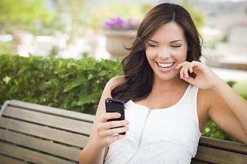 Image showing Young Adult Female Texting on Cell Phone Outdoors