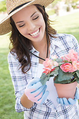 Image showing Young Adult Woman Wearing Hat Gardening Outdoors
