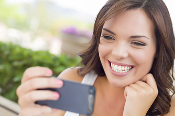 Image showing Young Adult Female Texting on Cell Phone Outdoors