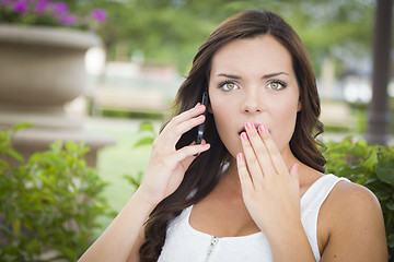 Image showing Shocked Young Adult Female Talking on Cell Phone Outdoors