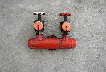 Image showing Red iron valve on a concrete wall