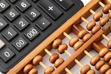 Image showing Ancient abacus and modern calculator