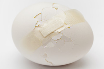 Image showing Cracked white egg with plastic plaster