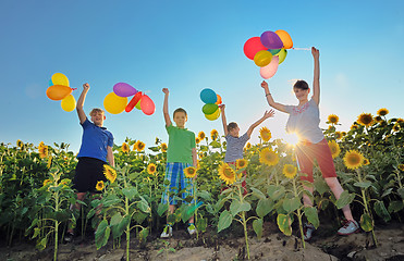 Image showing happy childrens jumping on meadow with balloons