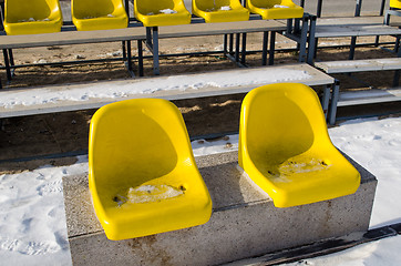 Image showing two yellow plastic chairs on the cement platform 