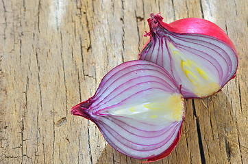 Image showing Red onions isolated on wooden background
