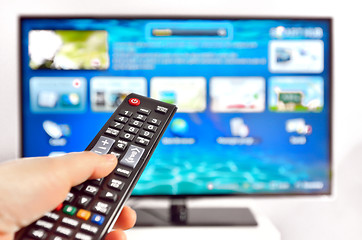 Image showing Smart tv and  hand pressing remote control