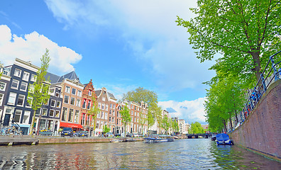 Image showing Traditional Houses and house boat along canal in Amsterdam